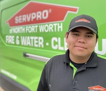 image of male standing in front of green van with Servpro logo