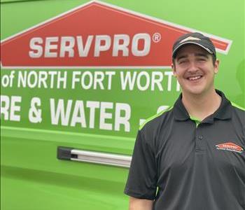 Male standing in front of green vehicle with Servpro logo