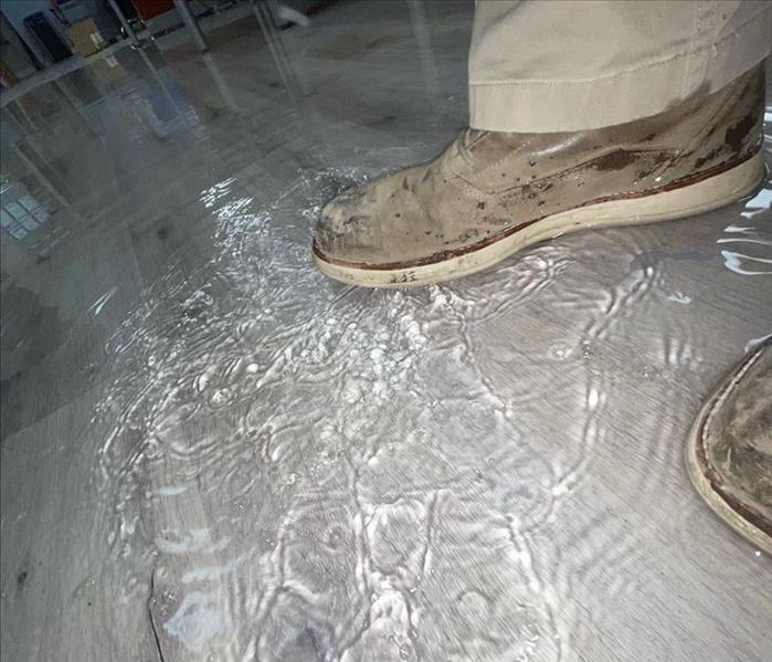 image of work boot stepping into water on vinyl floor
