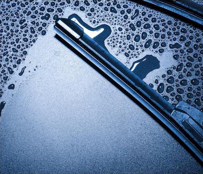 Close-up image of a wiper blade wiping away condensation on a car windshield