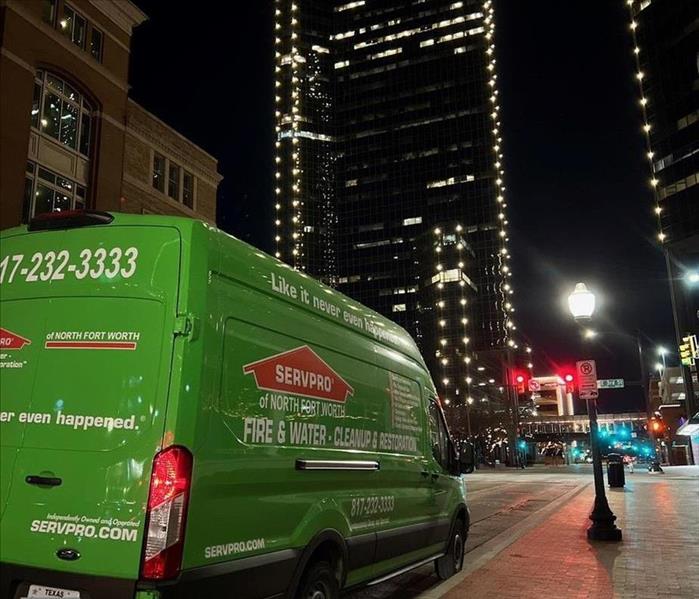 image of green van and city buildings at night